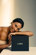 Woman leaning over a Lutea product box