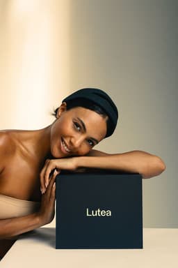 Woman leaning over a Lutea product box